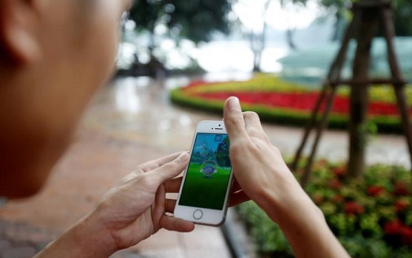 A man plays "Pokemon Go" by Hoan Kiem Lake in Hanoi, Vietnam, August 18, 2016. REUTERS/Kham