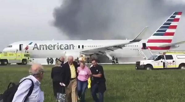 In this photo provided by passenger Jose Castillo, fellow passengers walk away from a burning American Airlines jet that aborted takeoff and caught fire on the runway at Chicago's O'Hare International Airport on Friday, Oct. 28, 2016. Pilots on Flight 383 bound for Miami reported an engine-related mechanical issue, according to an airline spokeswoman. (Jose Castillo via AP)