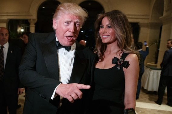 Melania Trump, right, looks on as her husband President-elect Donald Trump talks to reporters during a New Year's Eve party at Mar-a-Lago, Saturday, Dec. 31, 2016, in Palm Beach, Fla. (AP Photo/Evan Vucci)