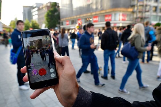 HANOVER, GERMANY - JULY 15: A young players holds his smartphone while playing "Pokemon Go" on July 15, 2016 in Hanover, Germany. 1.200 players have participated in the night walk through the city centre until midnight. "Pokemon Go" is a mobile game for smartphones, it uses advanced reality and geo-data to integrate the player in his search for new monsters or opponents within his location. The player now has to walk through the city, instead of spending time in front of a computer.  (Photo by Alexander Koerner/Getty Images)