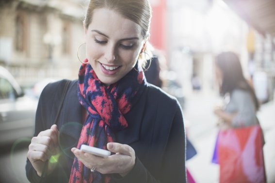 Woman using cell phone on city street