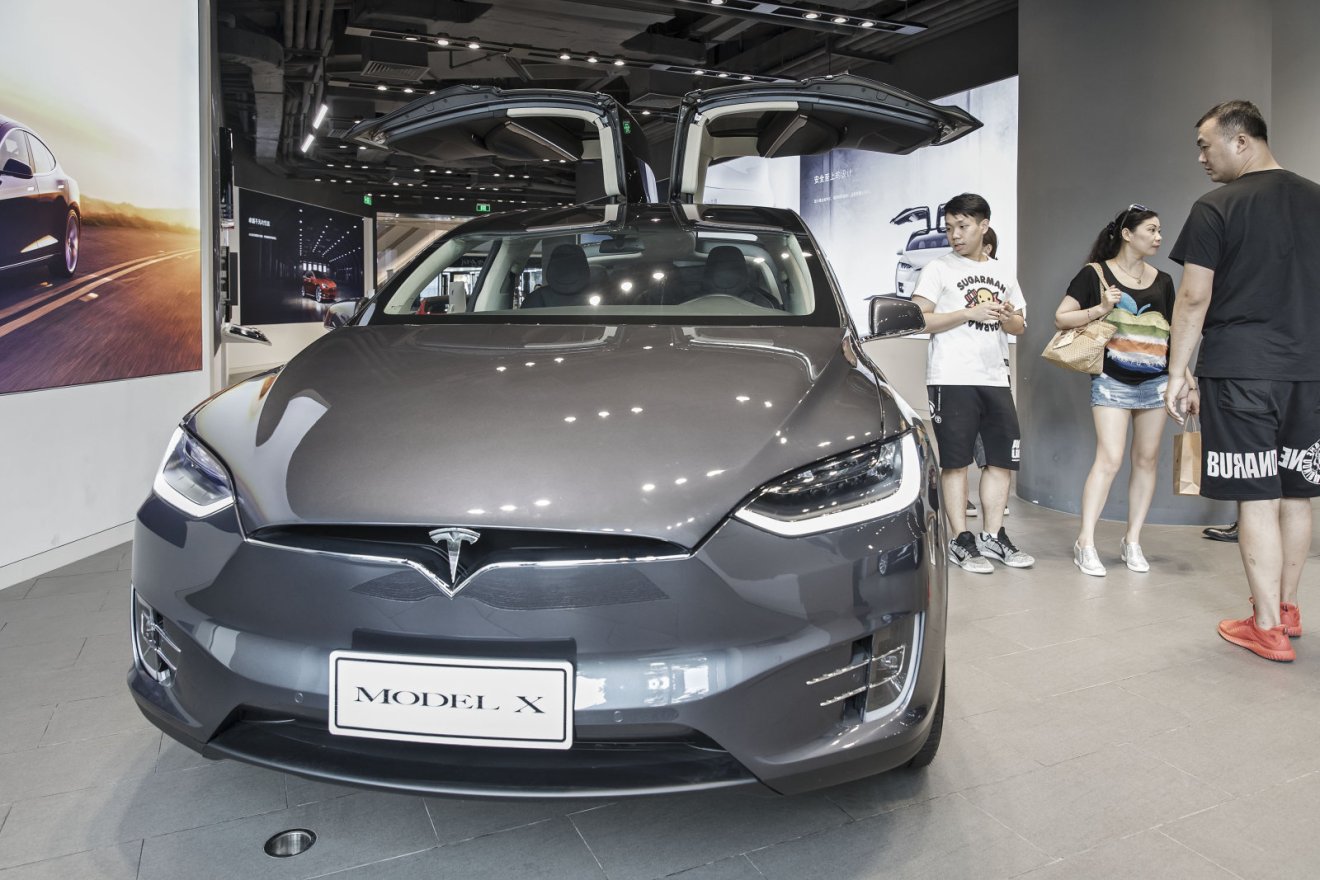 Customers look at a Tesla Motors Inc. Model X electric vehicle on display at the company's showroom in Shanghai, China, on Tuesday, Sept. 12, 2017. China will consider granting foreign investors more access into its electric-vehicle market as the worlds biggest market for battery-powered automobiles comes out with new policy initiatives to give a fillip to the industry. Photographer: Qilai Shen/Bloomberg via Getty Images