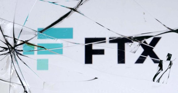 An FTX logo is seen through broken glass