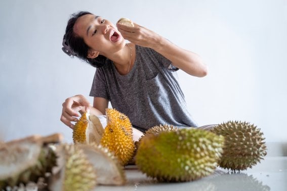 portrait of happy woman enjoy eating durian fruit